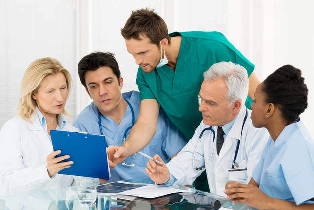 Team Of Doctors Examining Reports